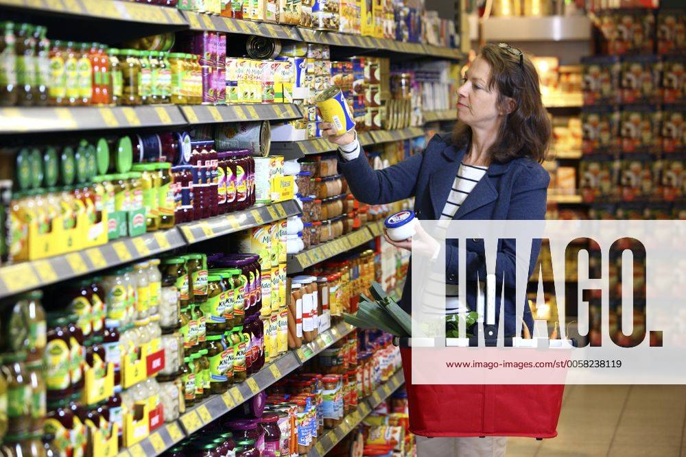 Lebensmittelabteilung, Frau kauft ein. Gemüsekonserven, Dosen. Grosser Supermarkt, Selbstbedienung. Deutschland, Europa.