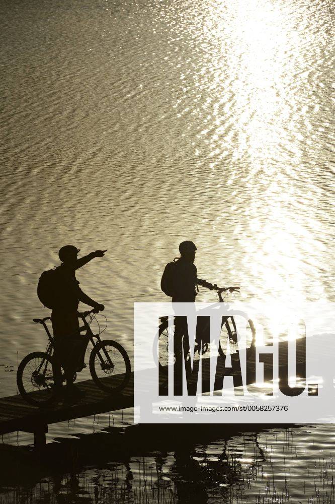 Radfahrer mit Elektro-Fahrrädern auf Badesteg, Klostersee Schloss Seeon, Chiemgau, Oberbayern, Bayern, Deutschland, Europa iblnex02288832