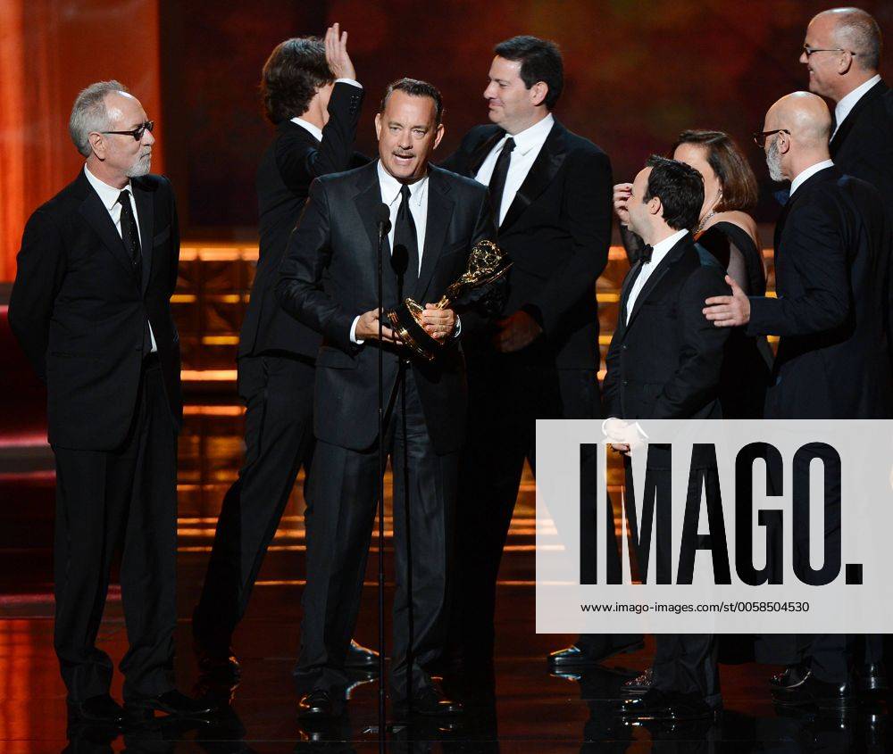 Producers Gary Goetzman, Jay Roach and Tom Hanks (L-R) accept Outstanding Miniseries or TV Movie Emmy for Game Change onstage during the 64th annual Primetime Emmy Awards at the Nokia Theatre in Los Angeles on September 23, 2012. At rear are the books authors, John Heilemann (L) and Mark Halperin. LAP20120923930