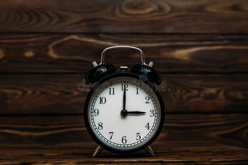 Clock on a wooden background. The clock shows the time of three o`clock in the afternoon. The clock shows the time of three o`, Clock on a wooden background. The clock shows the time of three o`clock in the afternoon. The clock shows the time of three o`clock in the morning. An image of a retro clock showing 03:00 pm/am. Copy space