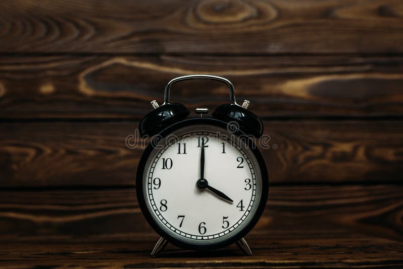 Clock on a wooden background. The clock shows the time of four o`clock in the afternoon. The clock shows the time four o`clock i, Clock on a wooden background. The clock shows the time of four o`clock in the afternoon. The clock shows the time four o`clock in the morning. An image of a retro clock showing 04:00 pm/am. Copy space