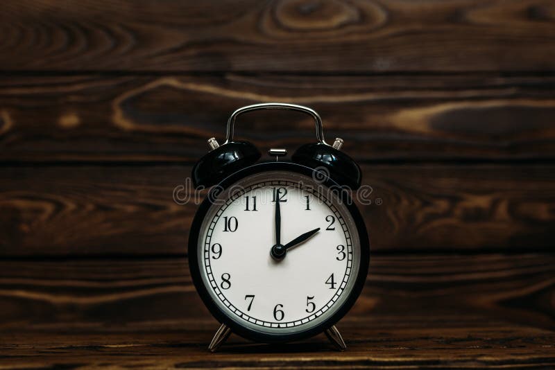 Clock on a wooden background. The clock shows the time of two o`clock in the afternoon. Clock showing the time of two o`clock in, Clock on a wooden background. The clock shows the time of two o`clock in the afternoon. Clock showing the time of two o`clock in the morning. An image of a retro clock showing 02:00 pm/am. Copy space