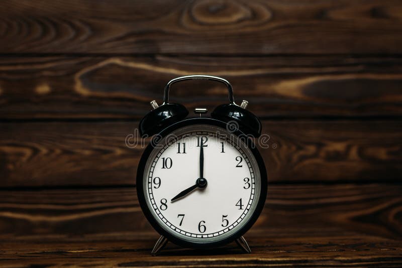 Clock on a wooden background. The clock shows the time of eight o`clock in the afternoon., Clock on a wooden background. The clock shows the time of eight o`clock in the afternoon. The clock shows the time of eight o`clock in the morning. An image of a retro clock showing 08:00 pm/am. Copy space