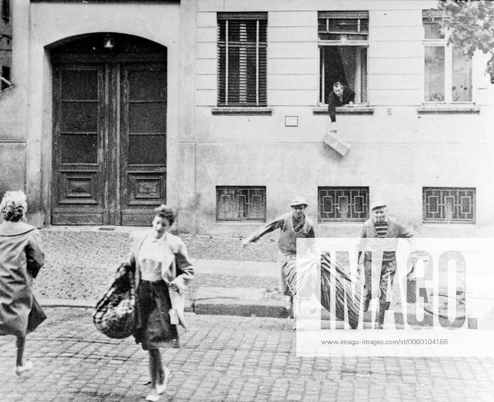 Berlin: Flashback to August 20th 1961 The picture shows the escape of an entire family just a week after the Berlin Wall was first built. In the back ground a man drops a parcel from a window of a house in Bernauer Strass which now marks the borderline. The pavement is west Berlin.. The flats in there houses were evacuated by communist on August 13th, But during the early days of the wall Bernauer Strasse was the easiest escape route, until East German sealed all doors and windows with bricks. 12 July 1969 UnitedArchives00935150