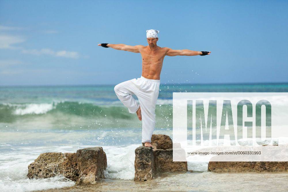 Erwachsener sportlicher mann macht yoga pilates meditation am strand im wasser