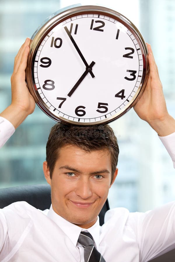 Portrait of smiling businessman holding clock to his head, Portrait of smiling businessman holding clock to his head