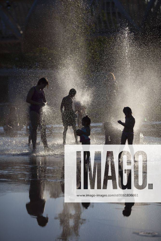 People enjoy in a font on the Manzanares riverside. After of a rare cold weather finally arrived the heat to Madrid city. Spain.
