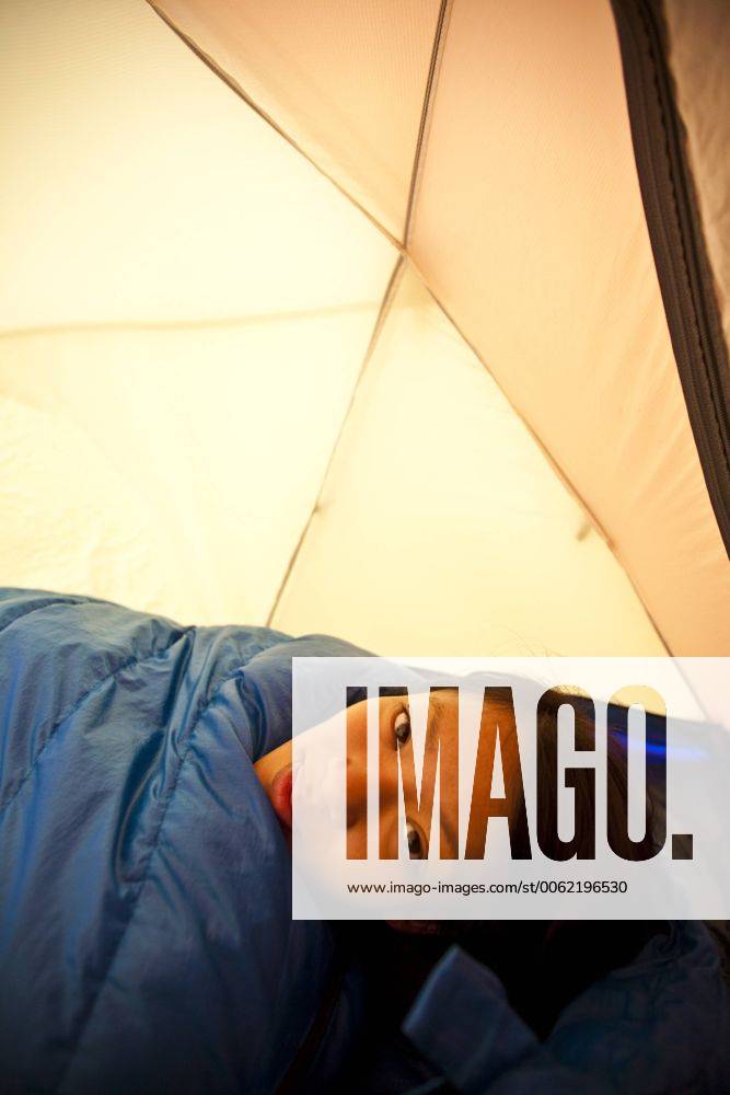 A young woman wakes up while camping in Jasper Provincial Park, Alberta, Canada acp49206