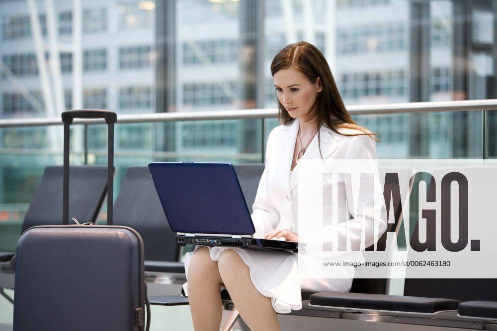 Business woman sitting in airport lounge, using laptop model released MAEF00113