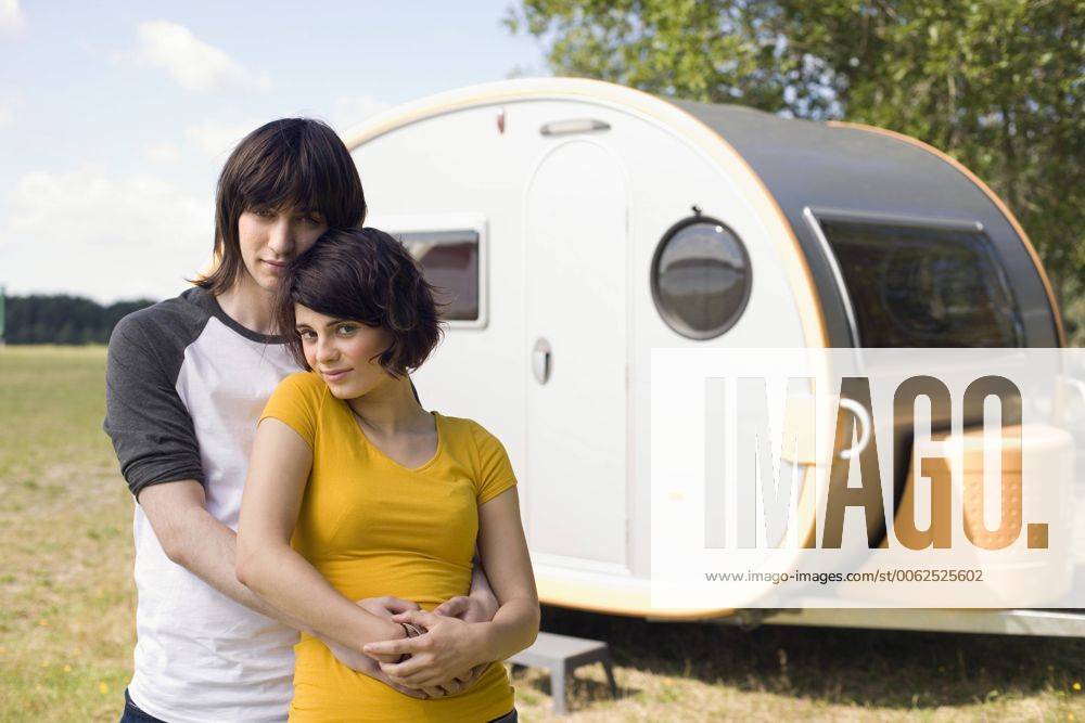 Germany, Leipzig, Ammelshainer See, Young couple embracing, in background camping trailer, portrait model released property released WESTF09406