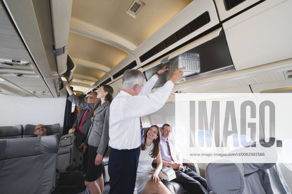 Germany, Bavaria, Munich, Passengers removing hand luggage from shelf in business class airplane cabin model released property released WESTF016867