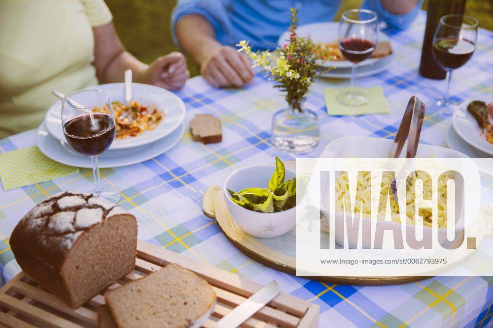 Table with pasta, bread and wine in evening light model released Symbolfoto property released MFF001313