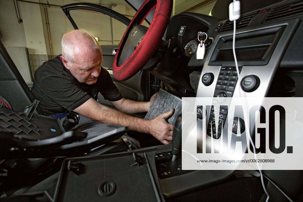 Kfz-Mechaniker in Volvo-Werkstatt DEU, Deutschland, Berlin, 2007-09-26: Volvo-Vertragswerkstatt Dieter Lochner in Berlin-Steglitz. Kfz-Mechaniker Frank Kritz tauscht den Pollenfilter eines Volvo V50 aus. Mechaniker im Fussraum des Fahrzeugs.