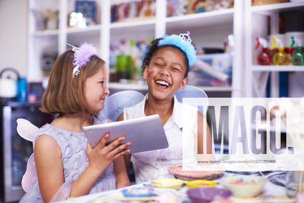 Two girls using digital tablet on a birthday party model released Symbolfoto property released ZEF001373