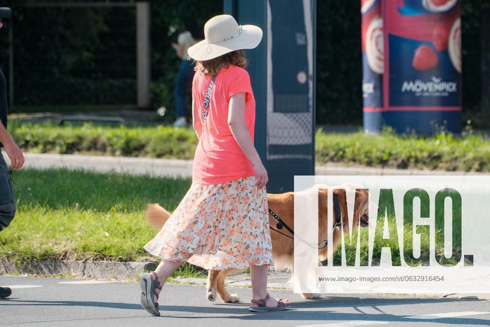 Düsseldorf 24.06.2024 Hund Hunde Gassi gehen gassigehen Spaziergänger spazieren Spaziergang Hundekot Hundekotbeutel Kotbeutel Hundescheisse Hundehaufen Sonnenhut Strohhut Basthut Rattanhut Modistin Hutschleife Hutkrempe Damenhut Frühlingsfarben Sommerfarben Sonnenschutz Sonnenbrand Sonnenstich Düsseldorf Nordrhein-Westfalen Deutschland