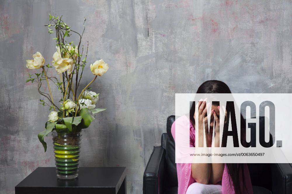 Weinende Frau auf einem Sessel 1035301542