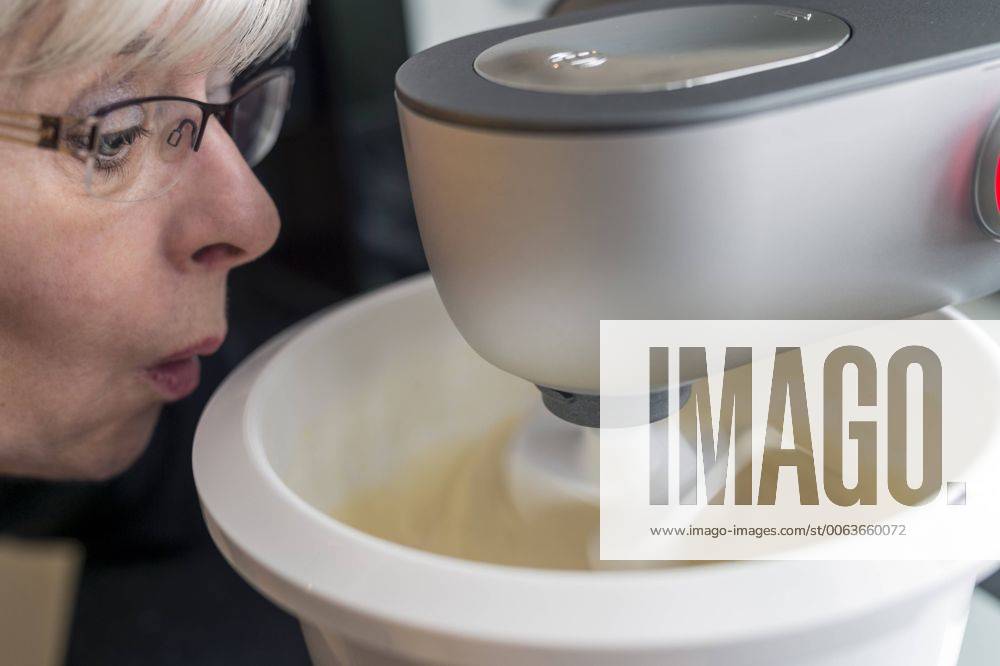 IMAGO Creative: Haushaltsgeräte - Küchenmaschine Eine Frau betrachtet staunend ihre Küchenmaschine, Deutschland, Europa ibxfhr04071218