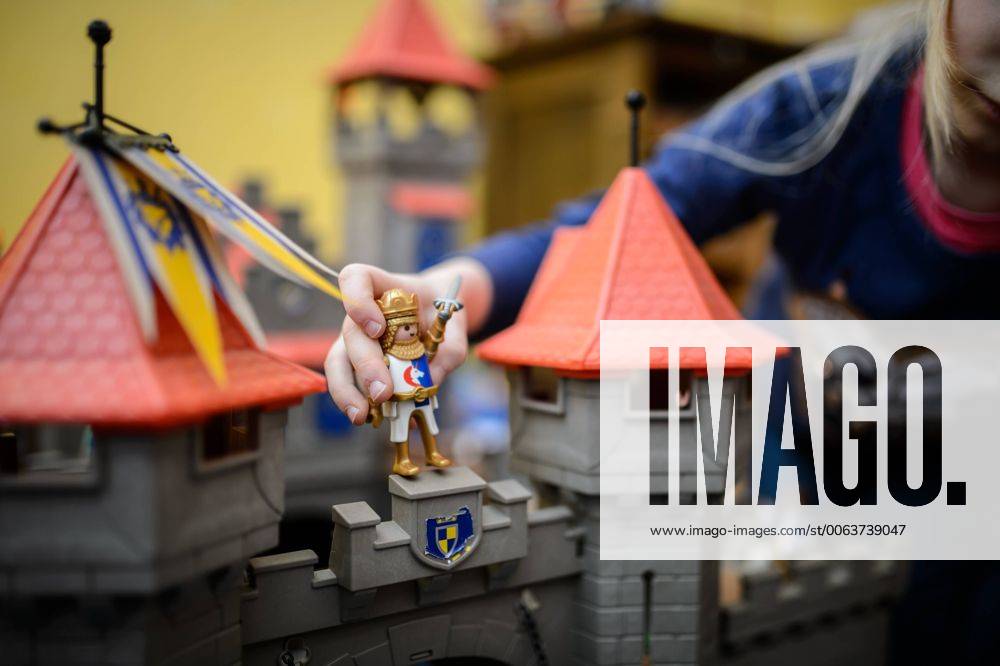 IMAGO Creative: Jahreszeit Winter, Fantasievoll drinnen spielen Ein Mädchen spielt mit ihrer Playmobil Ritterburg.