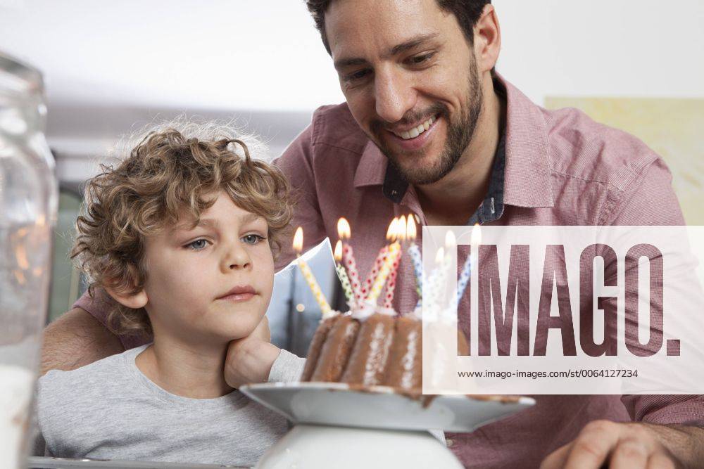 Father and son with birthday cake model released Symbolfoto property released RBF002425