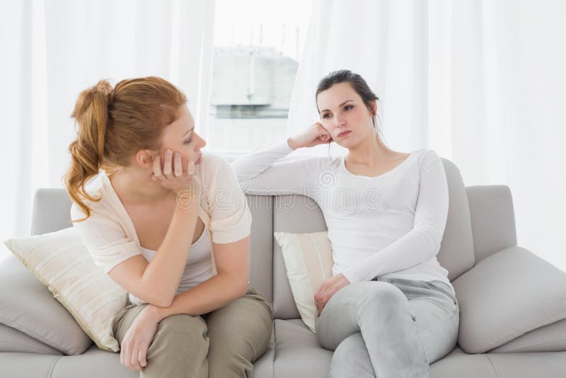 Unhappy friends not talking after argument on the couch, Unhappy young female friends not talking after argument at home on the couch