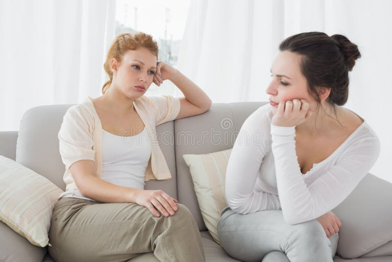 Unhappy friends not talking after argument on the couch, Unhappy young female friends not talking after argument at home on the couch