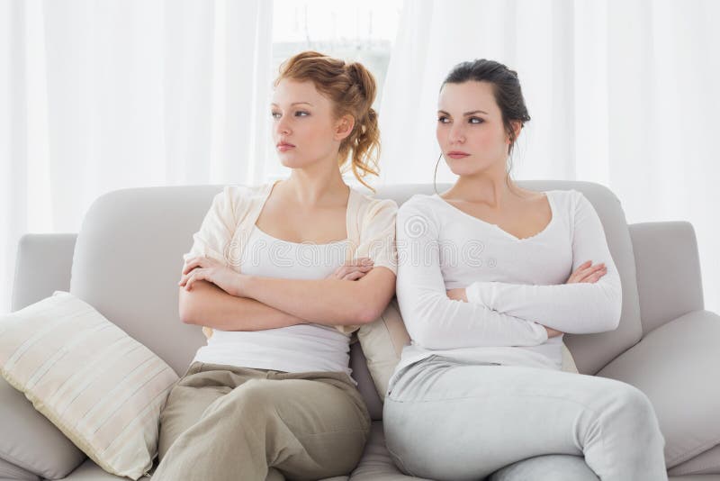 Unhappy friends not talking after argument on the couch, Unhappy young female friends not talking after argument at home on the couch