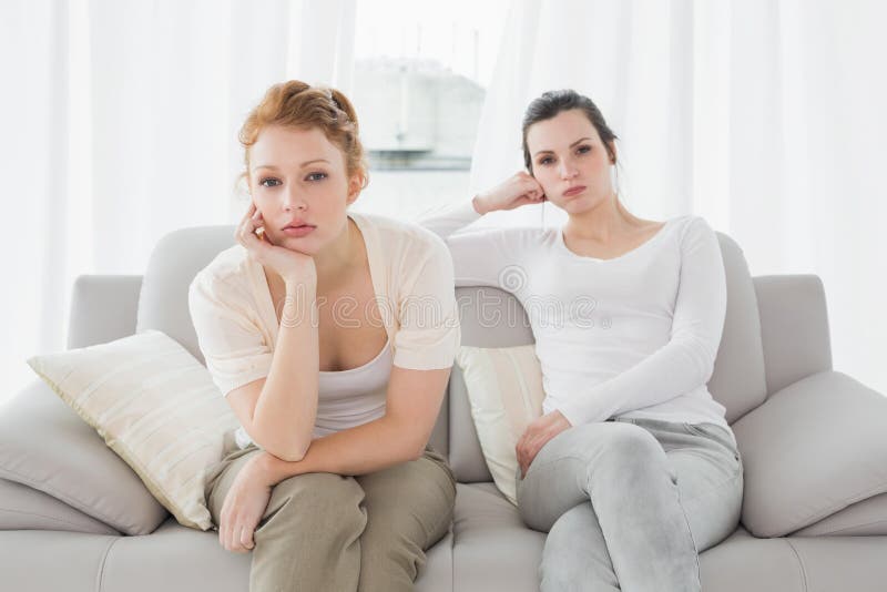 Unhappy friends not talking after argument on the couch, Unhappy young female friends not talking after argument at home on the couch