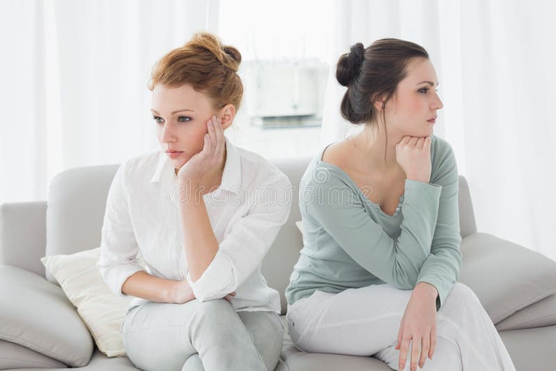 Unhappy friends not talking after argument on the couch, Unhappy young female friends not talking after argument at home on the couch