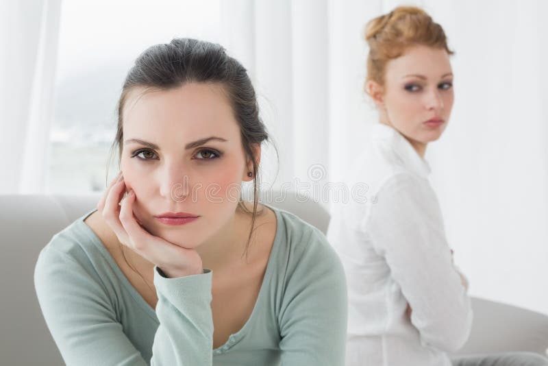Unhappy friends not talking after argument on the couch, Unhappy young female friends not talking after argument at home on the couch