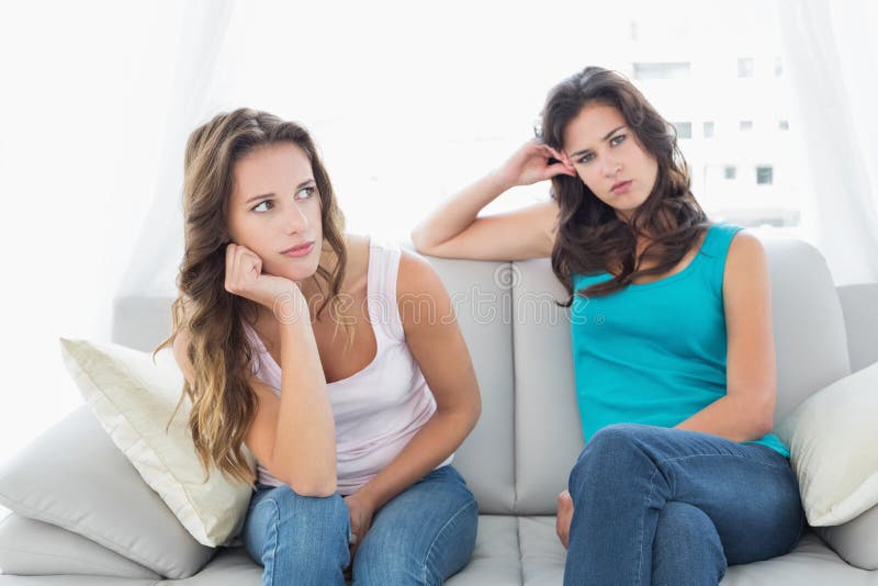 Unhappy friends not talking after argument at home, Unhappy young female friends not talking after argument at home on the couch