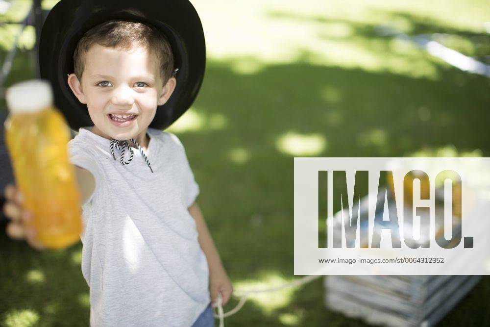 Boy in garden offering a cool drink model released Symbolfoto property released ZEF003225