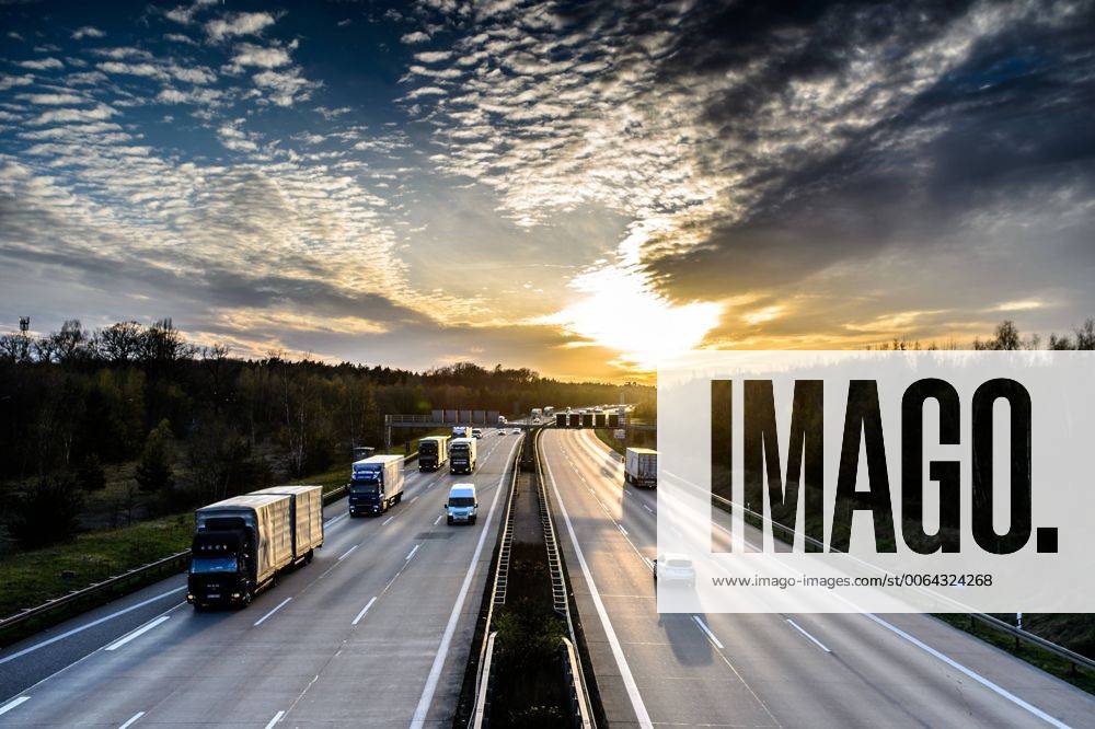 Autos und Lkw fahren auf der A2 bei Helmstedt (Niedersachsen) im Sonnenuntergang.
