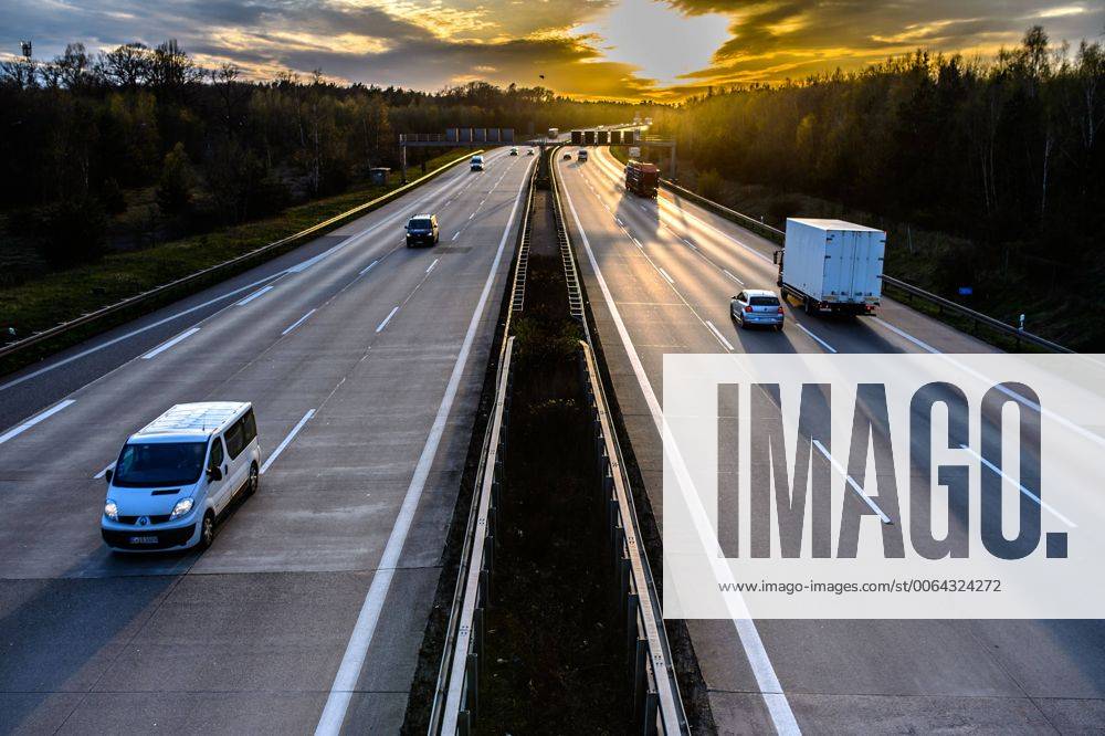 Autos und Lkw fahren auf der A2 bei Helmstedt (Niedersachsen) im Sonnenuntergang.
