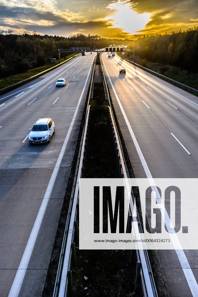 Autos und Lkw fahren auf der A2 bei Helmstedt (Niedersachsen) im Sonnenuntergang.