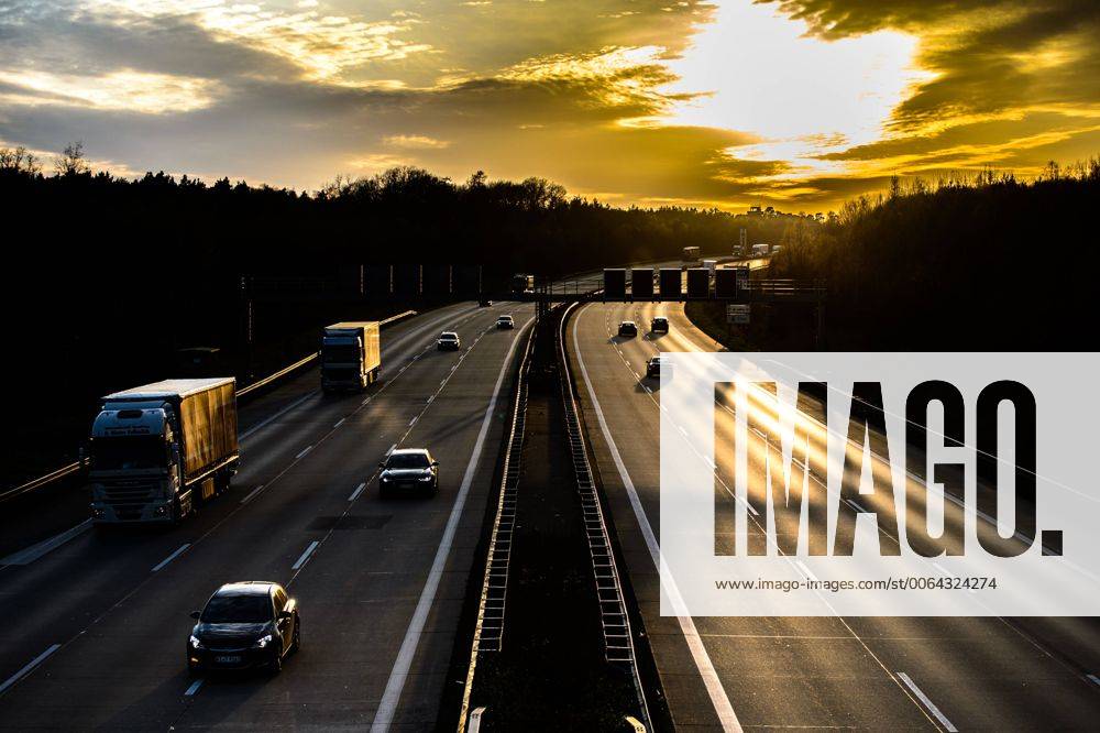 Autos und Lkw fahren auf der A2 bei Helmstedt (Niedersachsen) im Sonnenuntergang.