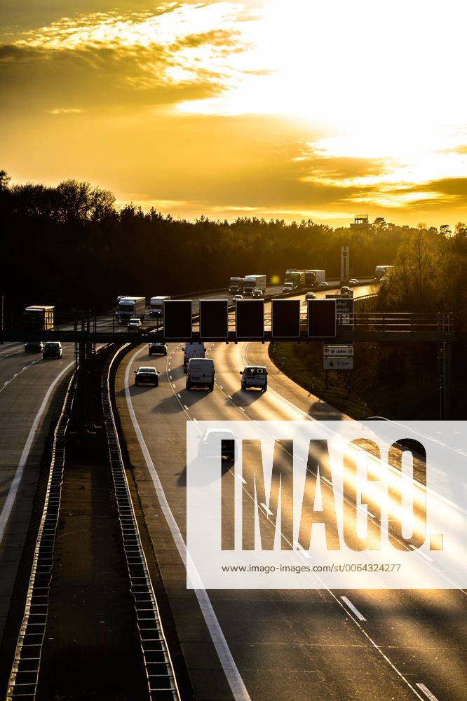 Autos und Lkw fahren auf der A2 bei Helmstedt (Niedersachsen) im Sonnenuntergang.