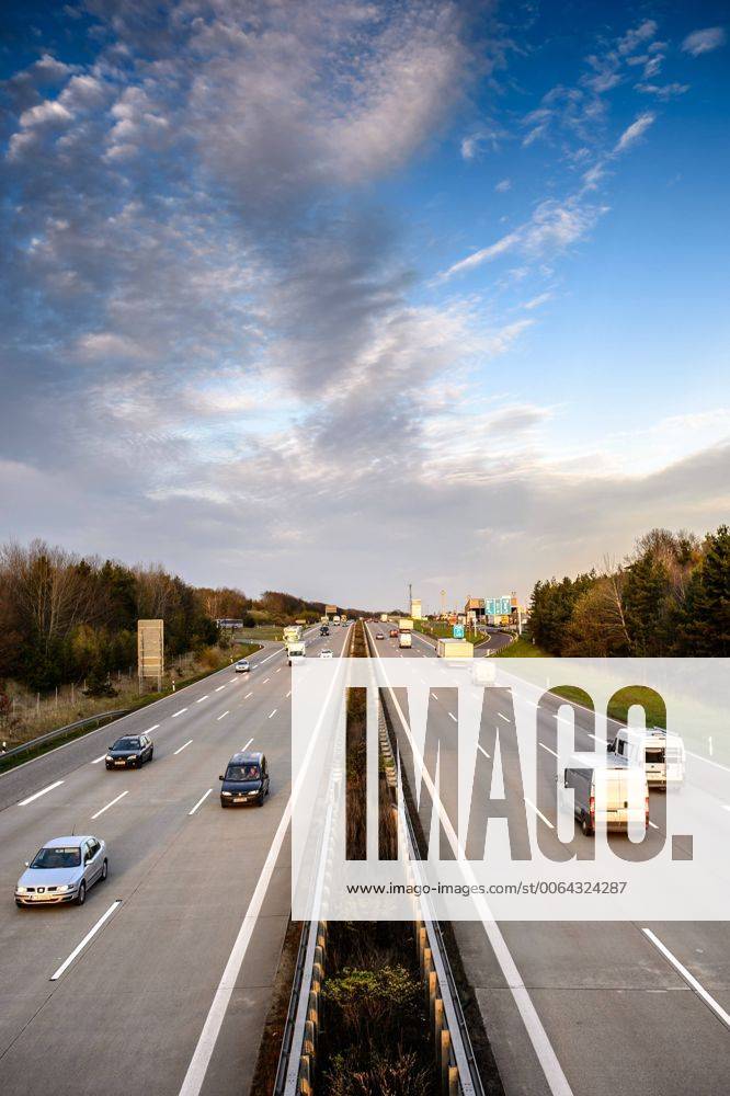 Autos und Lkw fahren auf der A2 bei Helmstedt (Niedersachsen) im Sonnenuntergang.