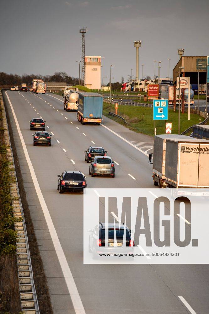 Autos und Lkw fahren auf der A2 bei Helmstedt (Niedersachsen) im Sonnenuntergang.