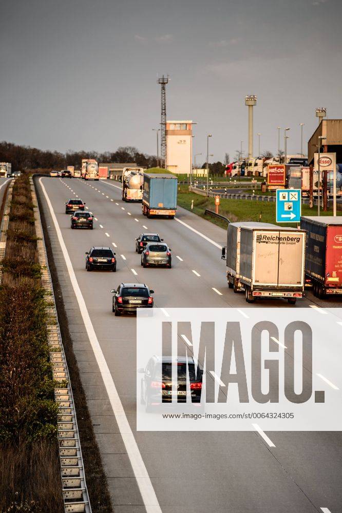 Autos und Lkw fahren auf der A2 bei Helmstedt (Niedersachsen) im Sonnenuntergang.