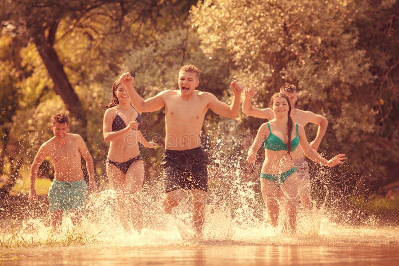 Summer joy friends having fun on river, Summer joy group of happy friends having fun while running and splashing on river