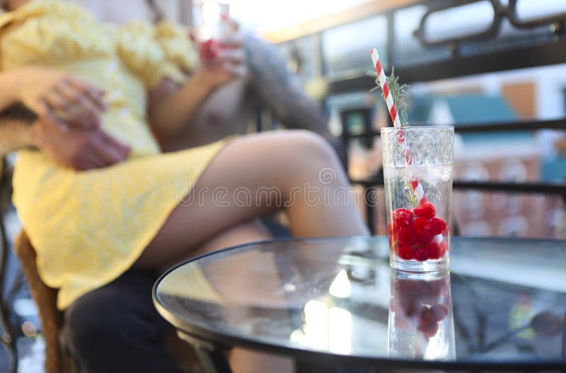 Couple in love drinking summer refreshing lemonade with rasberry on a balcony, Happy couple in love drinking summer refreshing lemonade with rasberry on a balcony