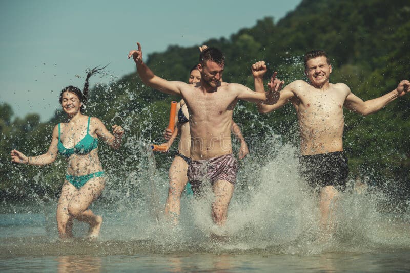 Summer joy friends having fun on river, Summer joy group of happy friends having fun while running and splashing on river