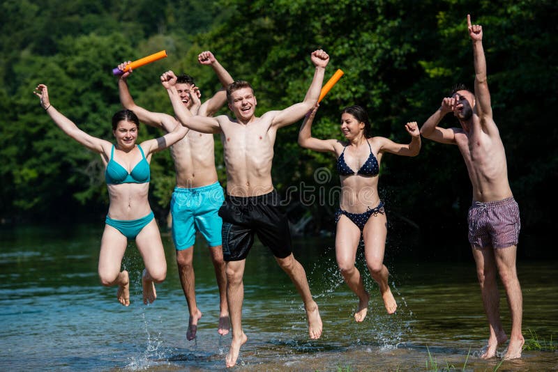 Summer joy friends having fun on river, Summer joy group of happy friends having fun while running and splashing on river