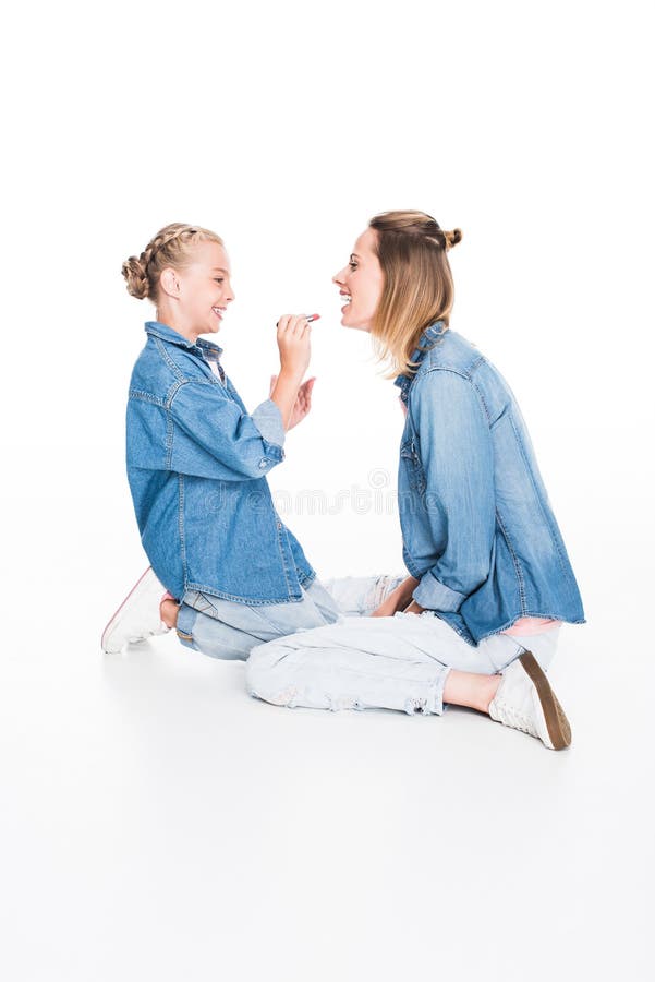 Mother and daughter applying makeup together,, mother and daughter applying makeup together, isolated on white