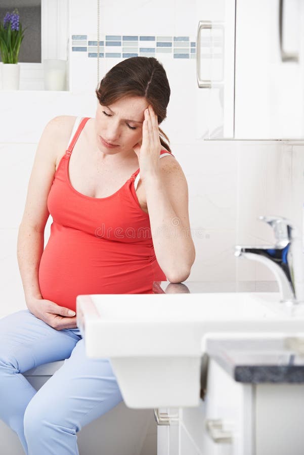 Pregnant Woman Suffering With Morning Sickness In Bathroom, Pregnant Woman With Morning Sickness In Bathroom model released