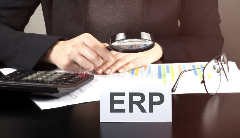 Close up Business woman using calculator and charts do math finance on wooden desk in office and business working background with, Close up Business woman using calculator and charts do math finance on the wooden desk in office and business working background with text ERP