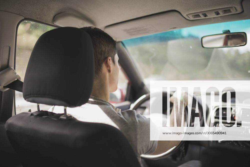 Young man driving car model released Symbolfoto RAEF000253