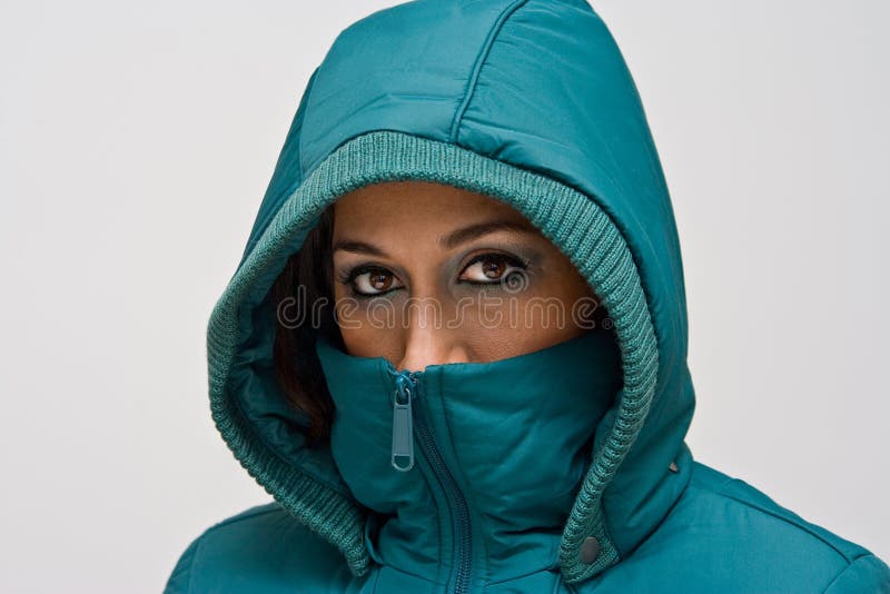 Young woman with green hood, A young woman wearing a green winter coat using the hood to cover her head so that only her eyes are visible, isolated on white model released