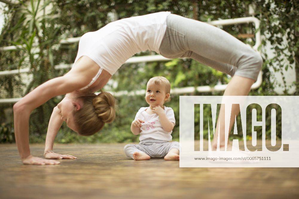 WELLNESS UND GESUNDHEIT Model Released: Junge Mutter macht Yoga Woman doing yoga exercise while baby watching her model released Symbolfoto ABF000630
