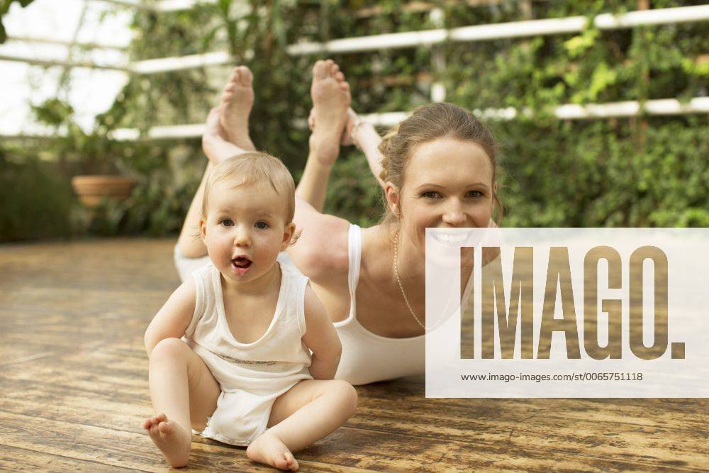 WELLNESS UND GESUNDHEIT Model Released: Junge Mutter macht Yoga Portrait of baby sitting in front of mother doing yoga exercise model released Symbolfoto ABF000637